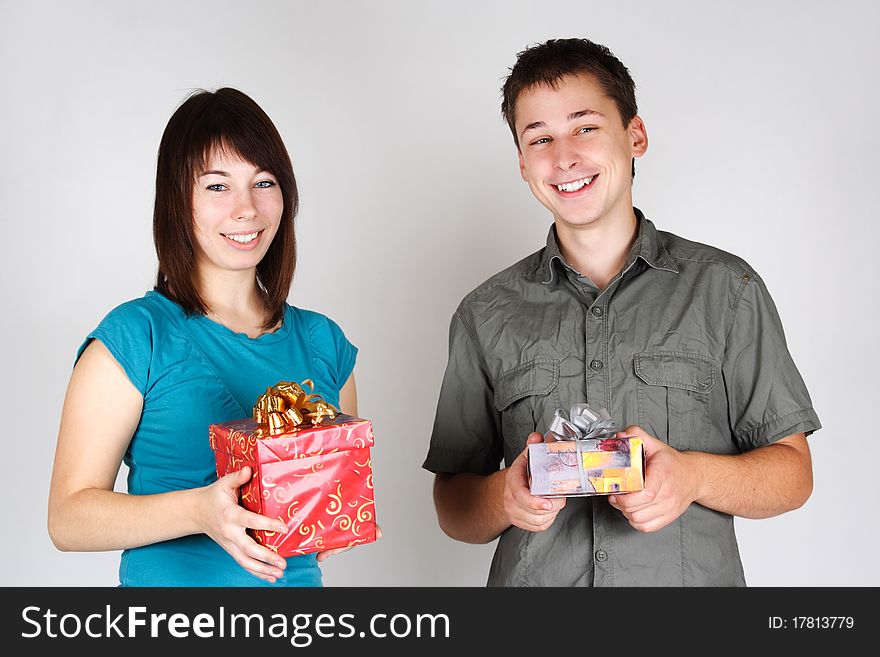 Young brunette girl and man holding gifts and smiling