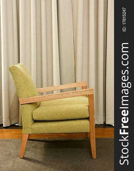 Green wooden and upholstered chair on rug.