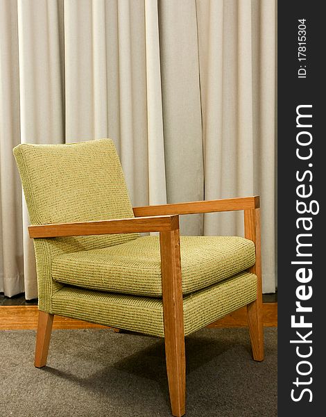 Single upholstered fabric and wooden chair on rug. Single upholstered fabric and wooden chair on rug.