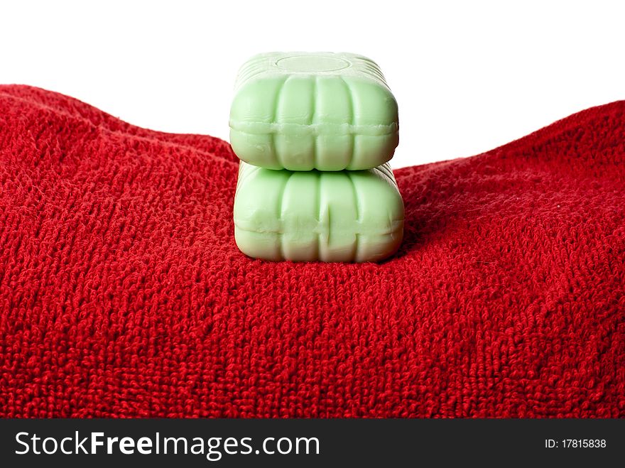 Two pieces of soap lying on red towel. Two pieces of soap lying on red towel.