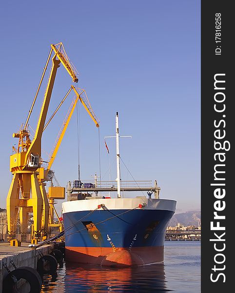 Unloading a docked ship with large cranes. Unloading a docked ship with large cranes