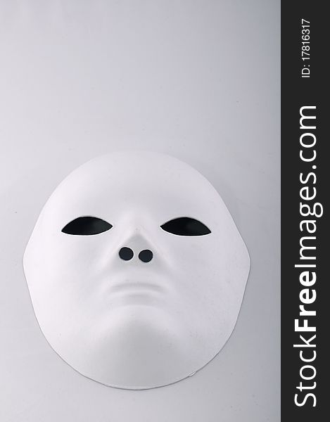 White mask with black eyes on a white background