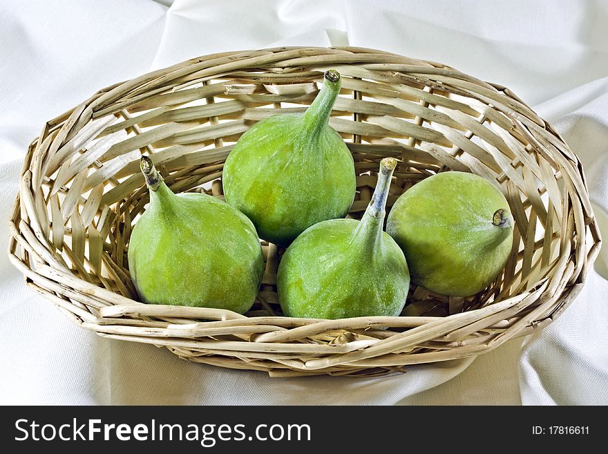 A close up of fresh green figs in a wicker basket. A close up of fresh green figs in a wicker basket