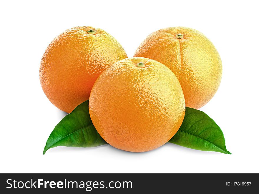 Three juicy oranges and green leaves on a white background. Three juicy oranges and green leaves on a white background