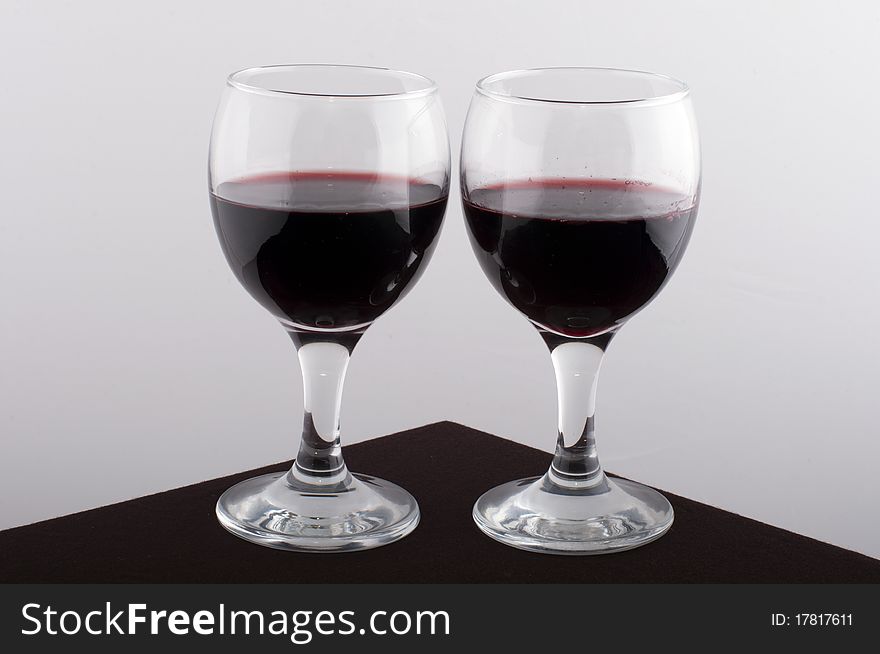 Glass wine glasses on a brown table with a white background. Glass wine glasses on a brown table with a white background