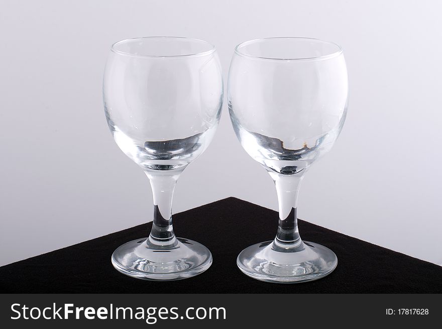 Glass wine glasses on a brown table with a white background. Glass wine glasses on a brown table with a white background