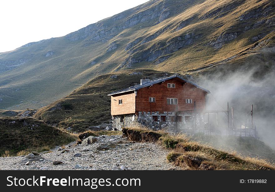 Wooden chalet in the Carpathian Mountains, Romania, with strong fog in one side. Wooden chalet in the Carpathian Mountains, Romania, with strong fog in one side