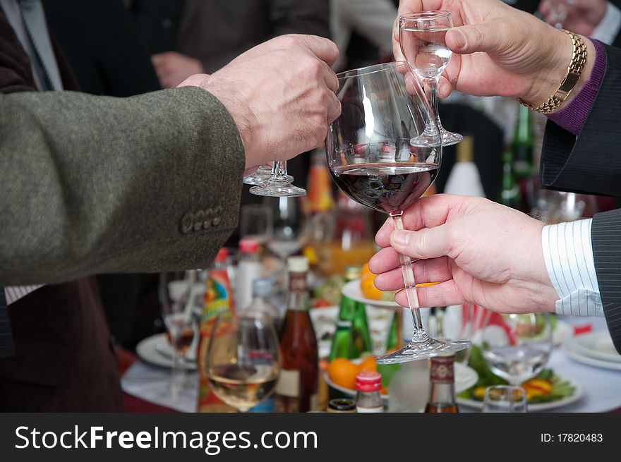 Hands of people hold wine glasses with alcoholic drinks. Hands of people hold wine glasses with alcoholic drinks.