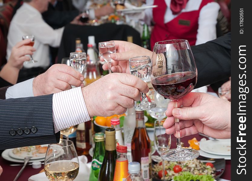 Hands of people hold wine glasses with alcoholic drinks. Hands of people hold wine glasses with alcoholic drinks.