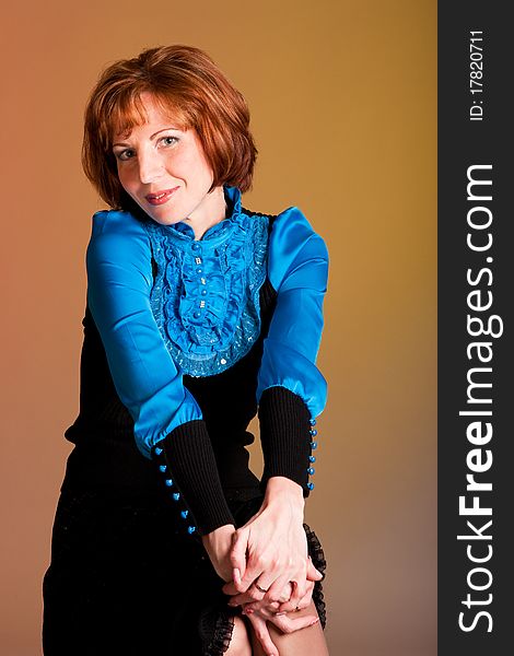 Charming young woman sitting in a studio. Charming young woman sitting in a studio