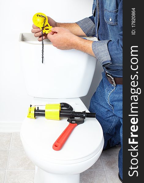 Plumber repairing a flush toilet. Plumber repairing a flush toilet