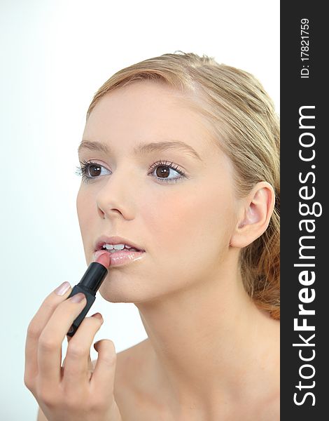 Portrait of a young woman applying make-up. Portrait of a young woman applying make-up