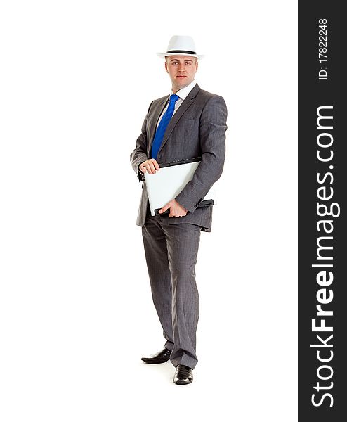 Young businessman in a suit and a hat with a laptop