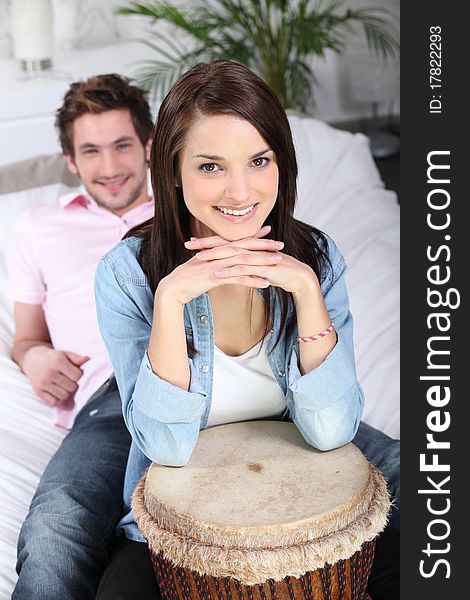 Young man and young woman smiling with a djembe. Young man and young woman smiling with a djembe
