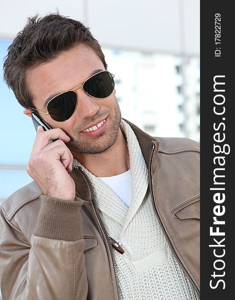 Young man on phone with sunglasses. Young man on phone with sunglasses