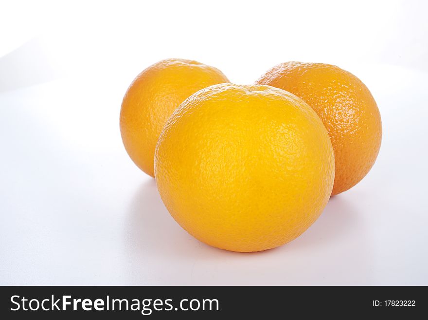 Three ripe oranges on white background