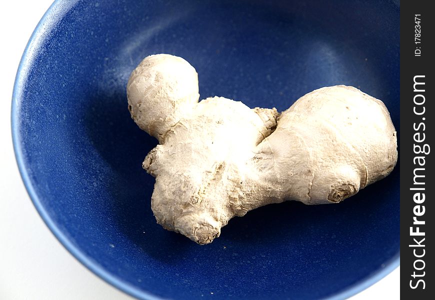A ginger rhizome in a blue bowl