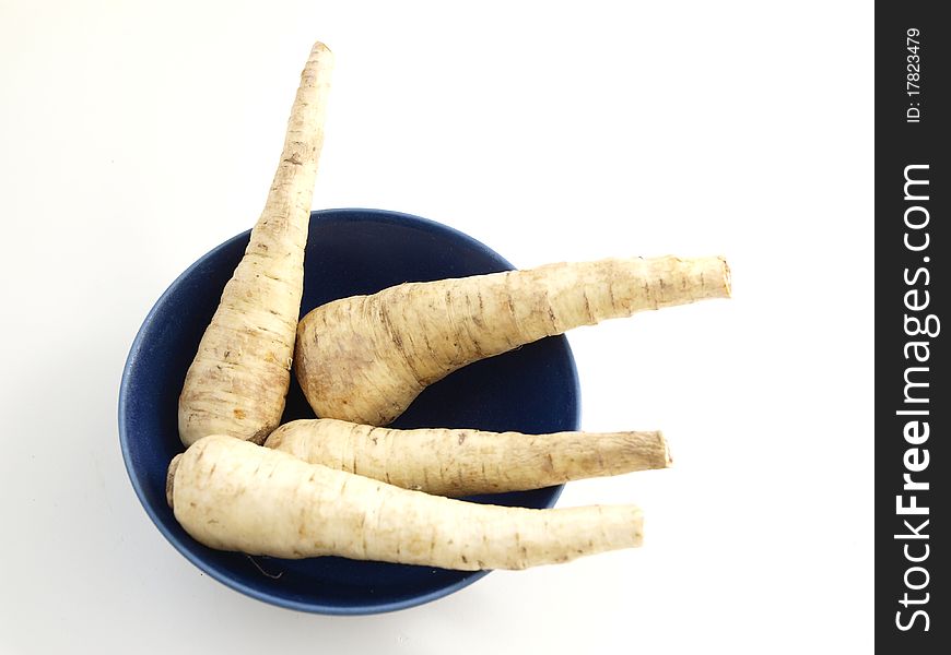 Four parsnips in a blue bowl