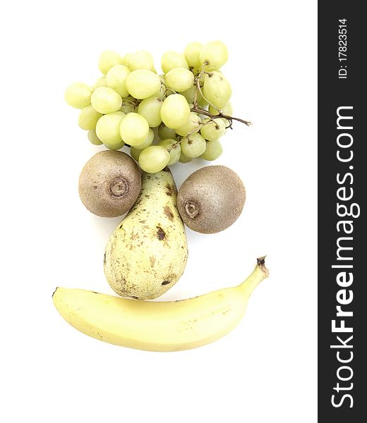 A funny fruit face with kiwifruit, pear, banana, and grapes on white background