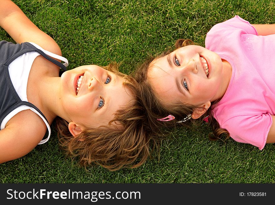 Two smiling girl lying on the grass. Summer 2010