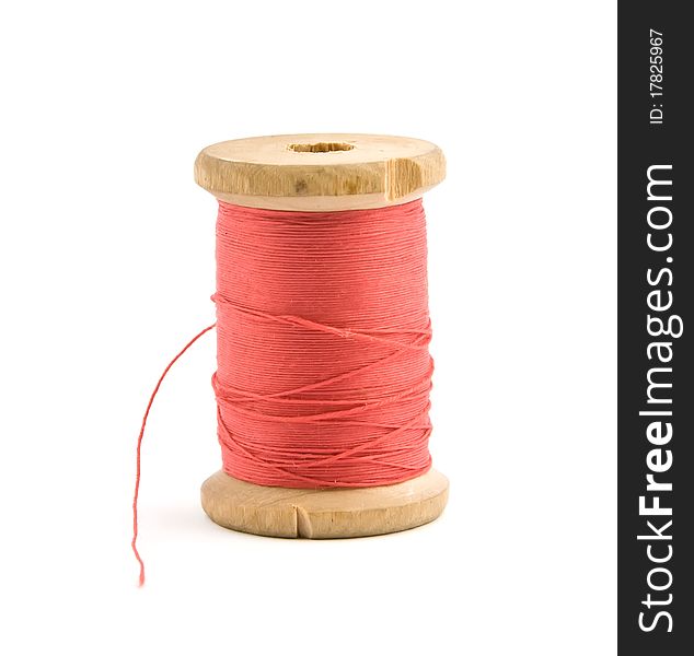 Bobbin with red thread over white. Bobbin with red thread over white