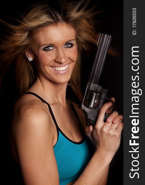 A woman is holding a gun and smiling. A woman is holding a gun and smiling.