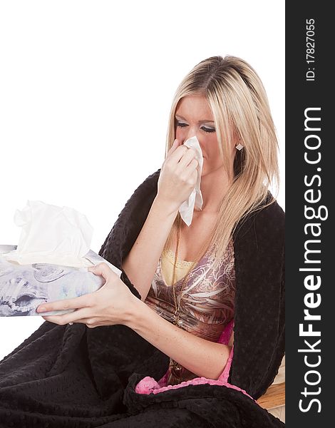 A woman is wrapped in a blanket holding a tissue. A woman is wrapped in a blanket holding a tissue.