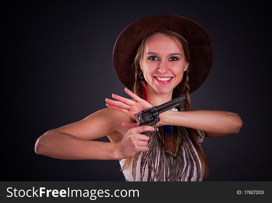 The American Indian girl in a cowboy's hat holds a pistol