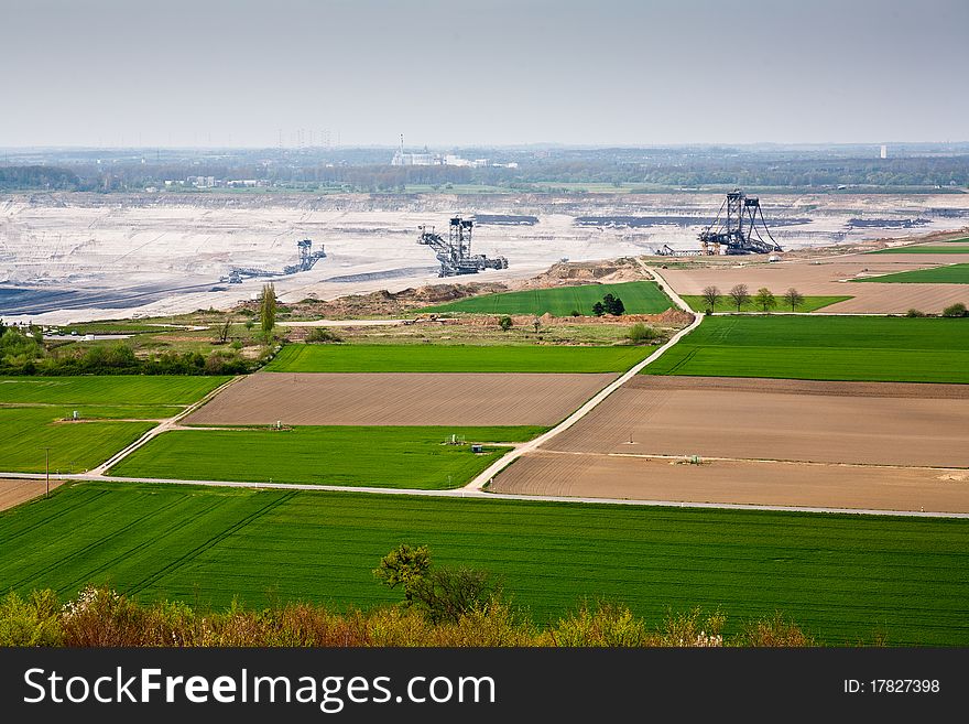 A coal mine in background, destroyed fields in foreground. A coal mine in background, destroyed fields in foreground