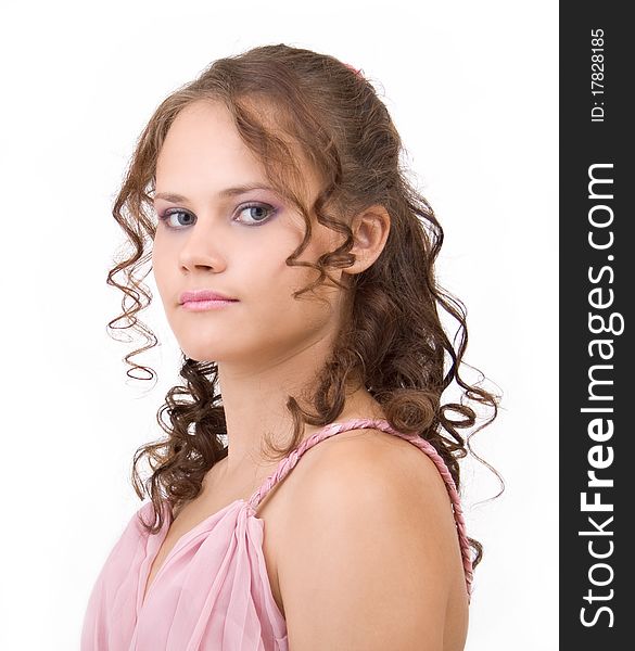 Portrait of a cute girl in a pink dress with curly hair.