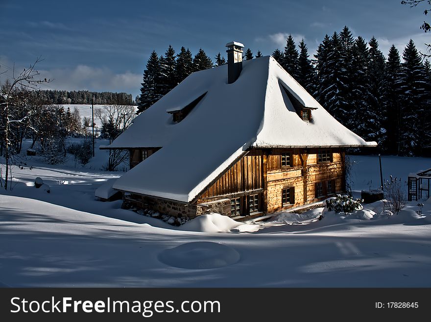 Block house in a winter landscape ,  blue cloudy sky