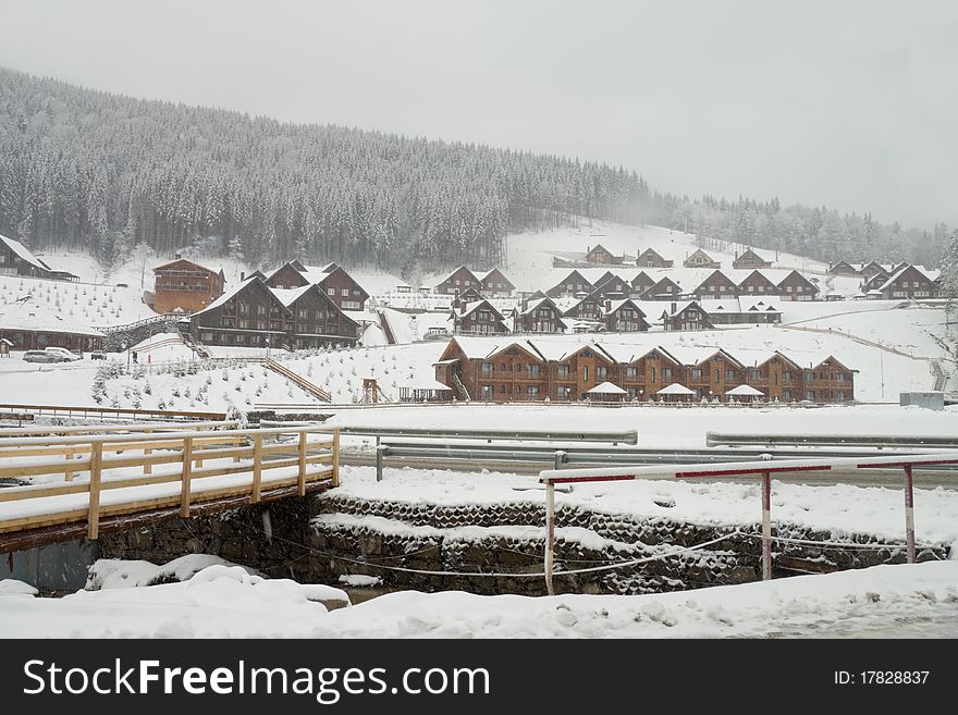 Mountain village on the bank of the river under falling snow. Mountain village on the bank of the river under falling snow