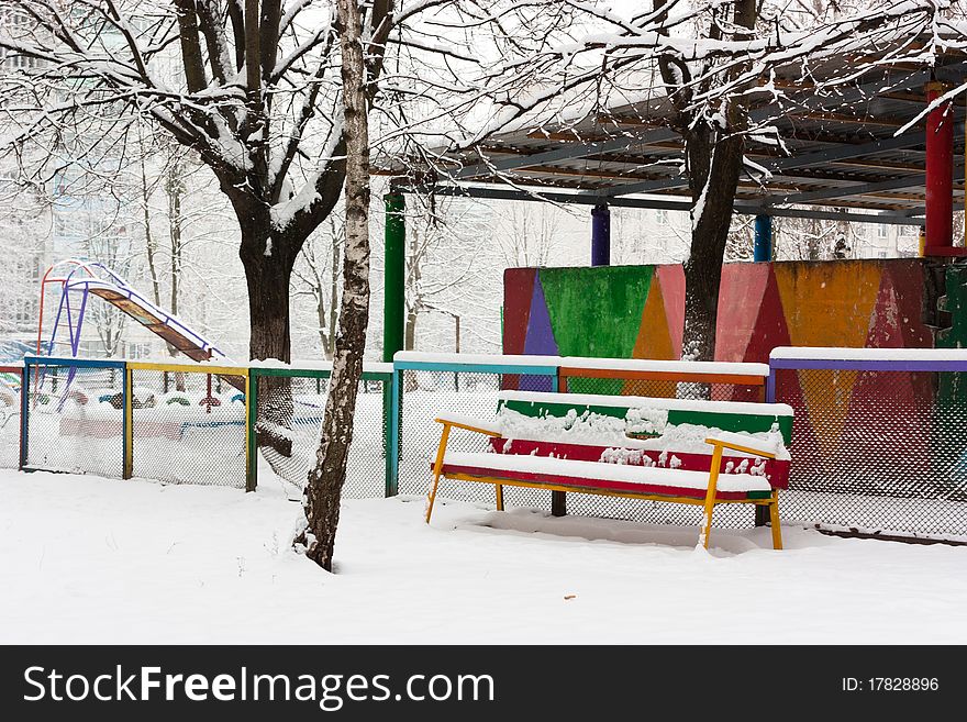 Colorful bench in snow in park