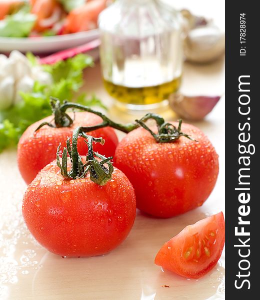 Fresh ripe tomato with olive oil and garlic on wet board