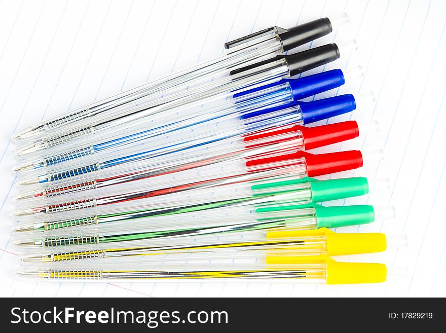 Collection of colored writing pens on a page in an exercise book. Collection of colored writing pens on a page in an exercise book