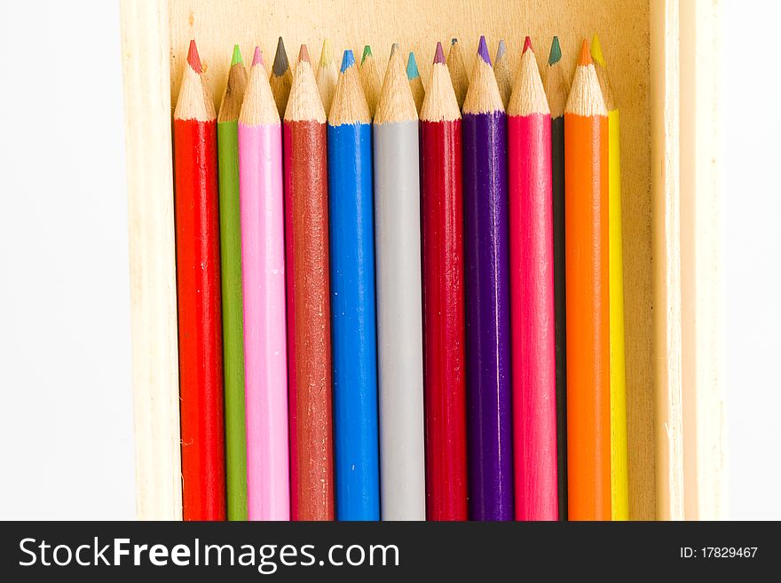 A colorful collection of coloring pencils in a wooden school pencil box. A colorful collection of coloring pencils in a wooden school pencil box