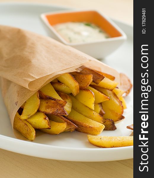 Fried potatoes with sauce on plate