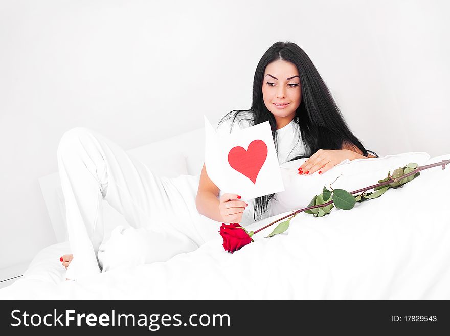 Beautiful brunette woman  at home on a Valentine's day  reading a Valentine's card