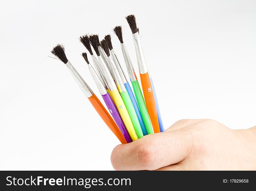 Different sizes watercolor paint  brushes held in a persons hand. Different sizes watercolor paint  brushes held in a persons hand