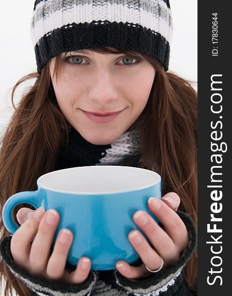 Beautiful girl with a smile, holding a large blue mug. Beautiful girl with a smile, holding a large blue mug