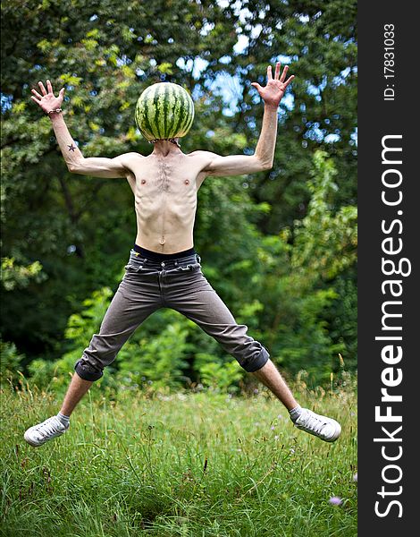 Humorous photo of a jumping boy with a watermelon instead of head. Humorous photo of a jumping boy with a watermelon instead of head