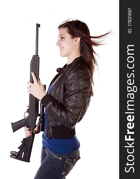 The side view of a woman with a shot gun in her hands with a smile on her face. The side view of a woman with a shot gun in her hands with a smile on her face.