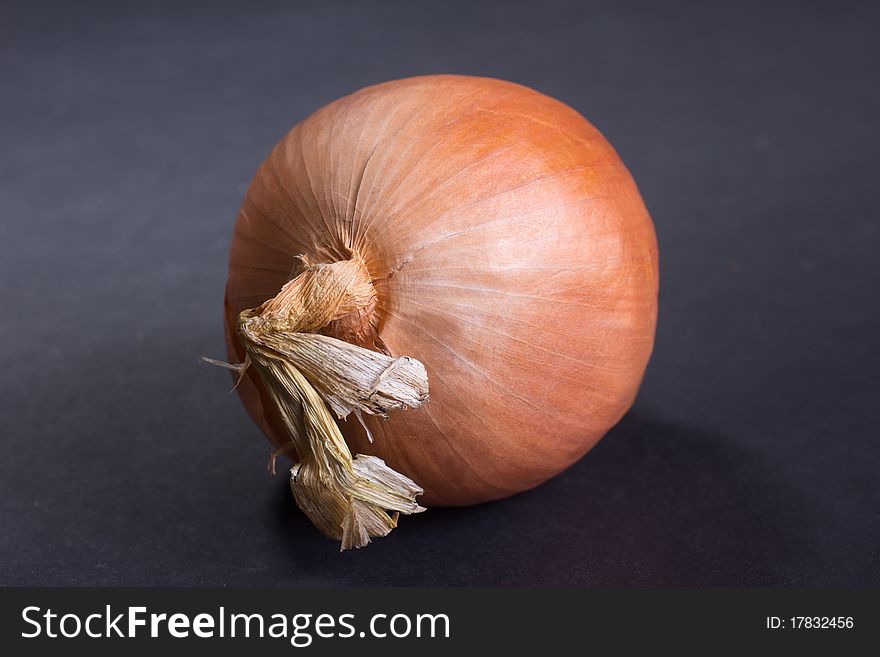 Image of an unpeeled onion on a black background