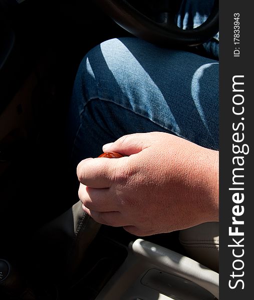 Male hand of driver shifting gears while driving a car. Male hand of driver shifting gears while driving a car