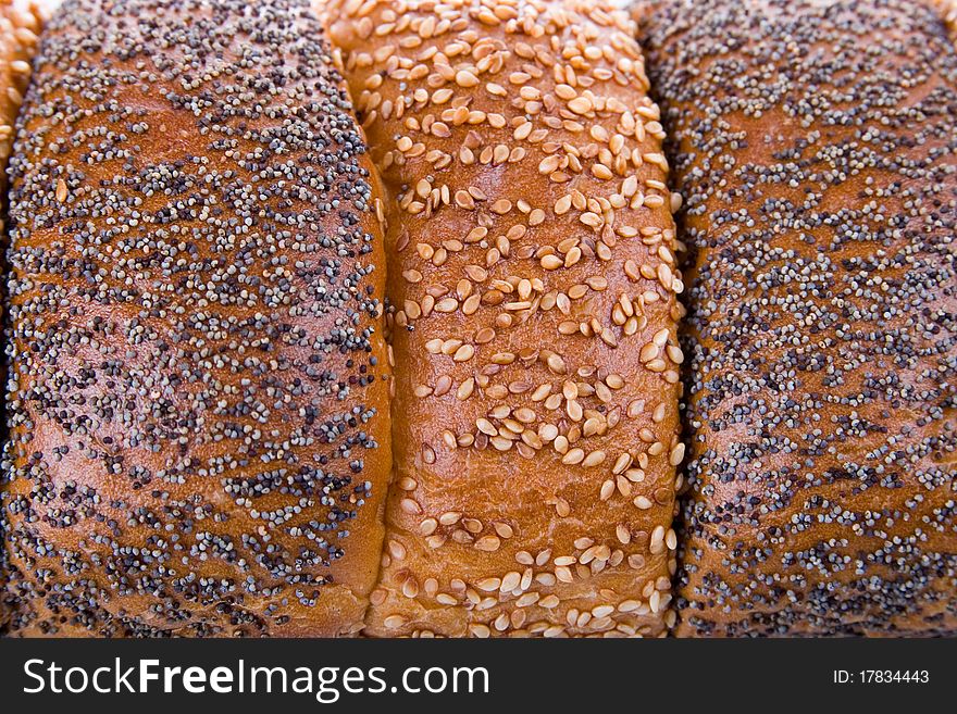 Background of fresh bread, sprinkled with sesame seeds. Background of fresh bread, sprinkled with sesame seeds