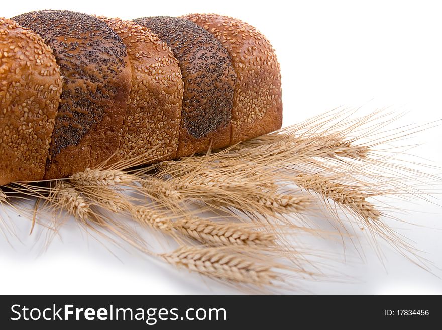 Fresh bread with ears of wheat on a white background