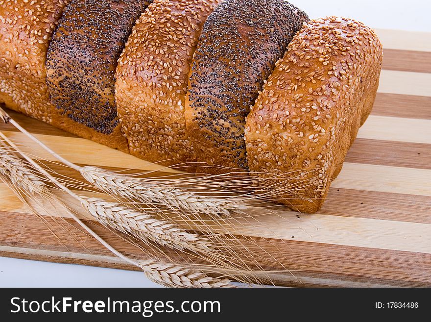 Fresh bread with ears of wheat  on a white background