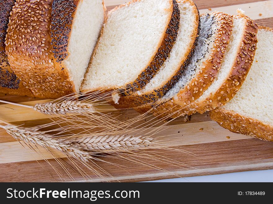 Fresh bread with ears of wheat  on a white background