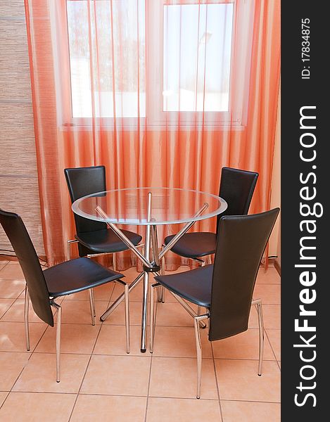 Round glass table in a kitchen interior.