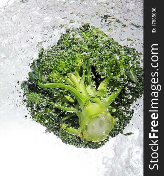 Fresh green broccoli dropped into water